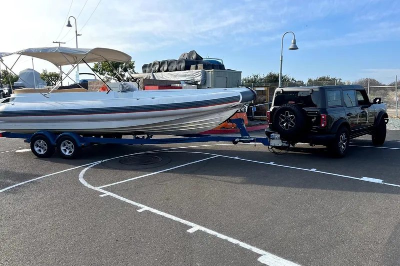 Slide: The Image of 2016 Castoldi jet tender on trailer, towed by a black SUV in a parking lot. - 15