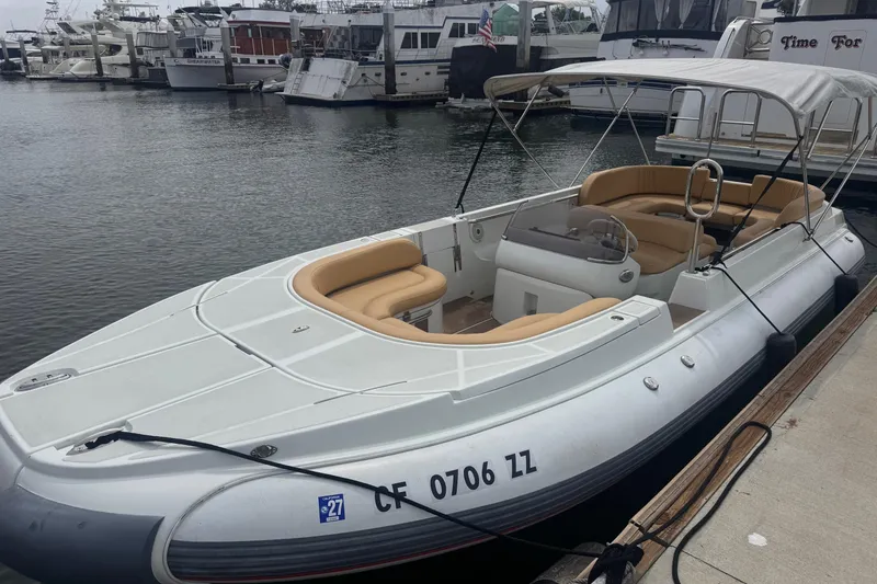 Slide: The Image of 2016 Castoldi jet tender docked, featuring beige seating and canopy, in a marina setting. - 4