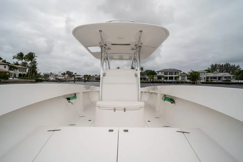 Slide: The Image of 2006 Venture Center Console boat with spacious deck and canopy, docked near waterfront homes. - 16