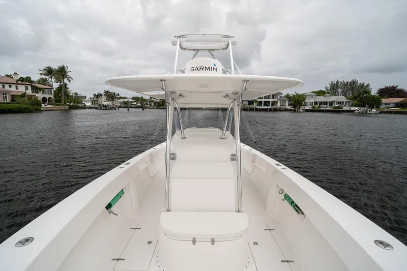 Slide: The Image of 2006 Venture Center Console boat on calm water, featuring Garmin equipment and luxurious waterfront homes. - 17