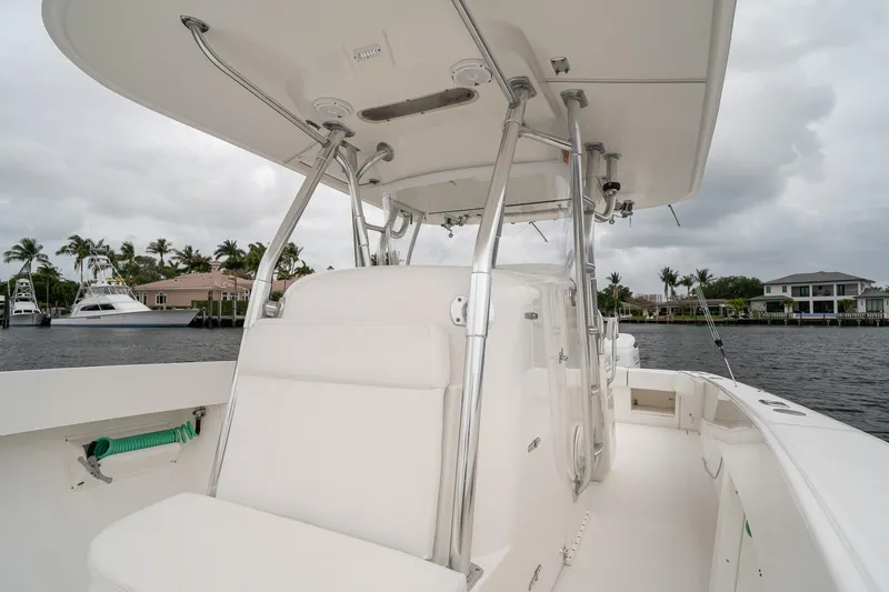 Slide: The Image of 2006 Venture Center Console boat with sleek design, docked near waterfront homes. - 19