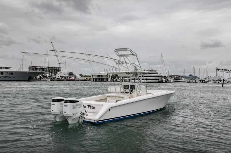 Slide: The Image of 2006 Venture Center Console boat with dual Suzuki engines in a marina setting. - 2