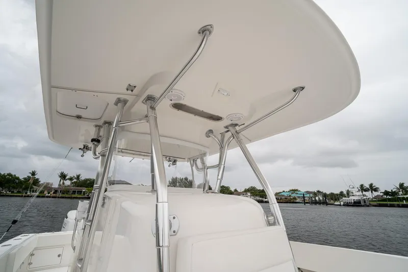 Slide: The Image of 2006 Venture Center Console boat with T-top, docked by waterfront homes. - 21