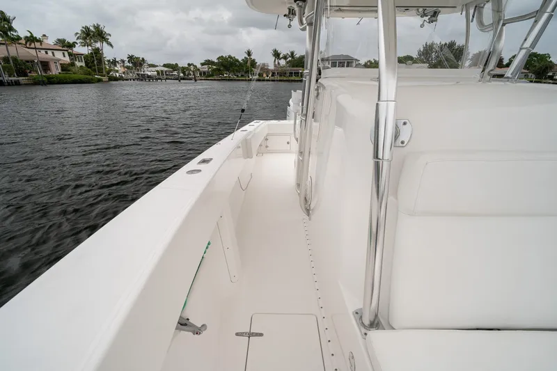 Slide: The Image of 2006 Venture Center Console boat on calm water, showcasing sleek white deck design. - 22