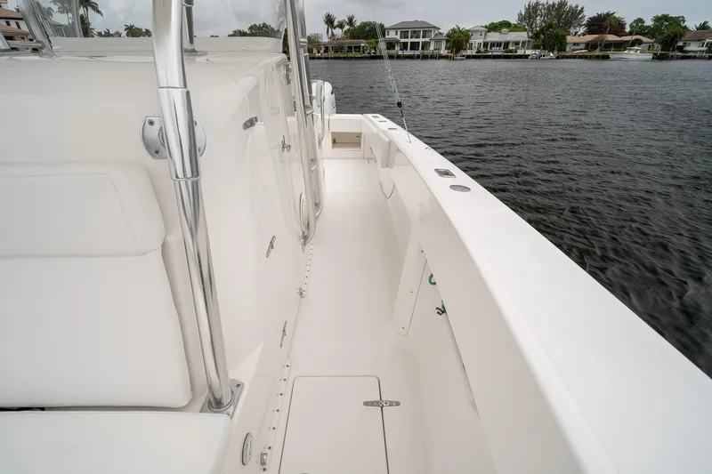 Slide: The Image of 2006 Venture Center Console boat deck, white interior, docked by waterfront homes. - 23