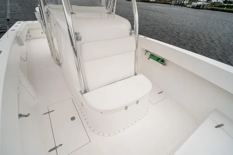 Slide: The Image of 2006 Venture Center Console boat interior with seating and storage, docked by the water. - 25