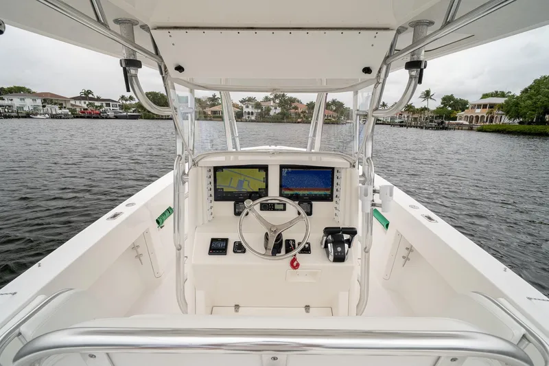 Slide: The Image of 2006 Venture Center Console boat interior with navigation equipment on a calm waterway. - 29