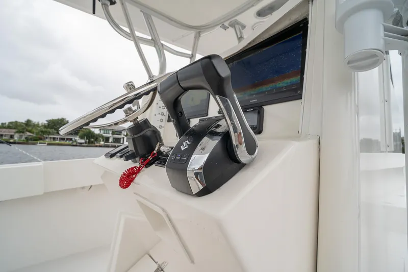 Slide: The Image of 2006 Venture Center Console boat controls with steering wheel and throttle levers. - 33