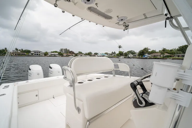 Slide: The Image of 2006 Venture Center Console boat interior with dual Suzuki engines on a calm waterway. - 34