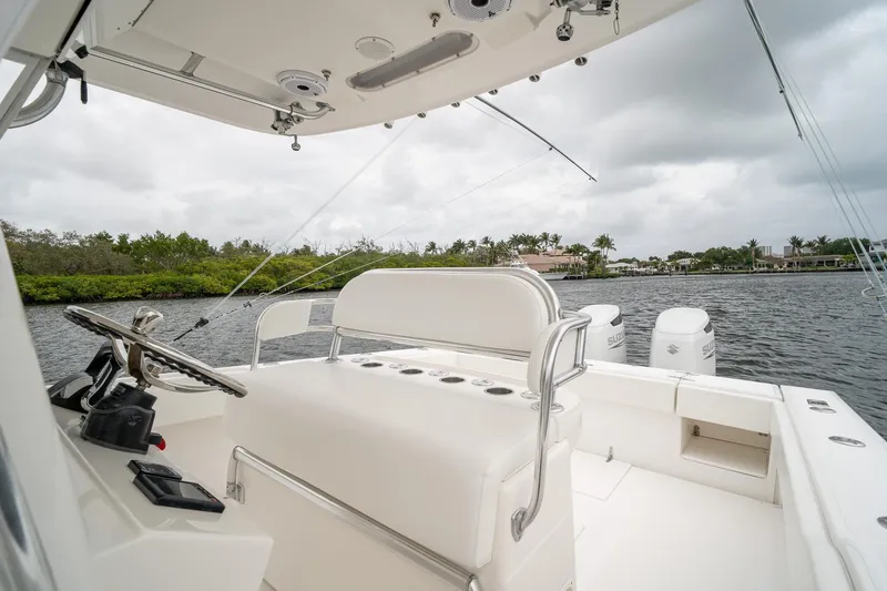Slide: The Image of 2006 Venture Center Console boat interior with steering wheel, white seating, and water view. - 36