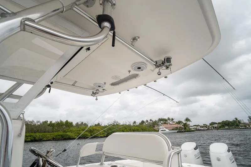 Slide: The Image of 2006 Venture Center Console boat with fishing rods and scenic waterfront view. - 37