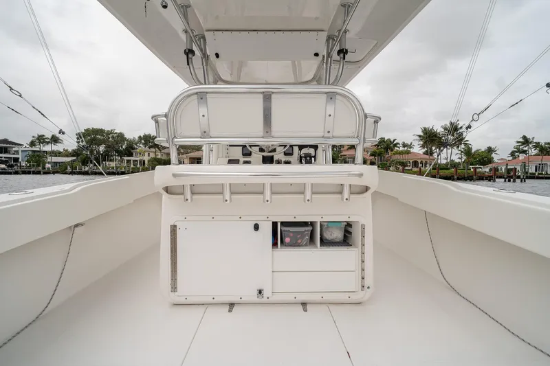 Slide: The Image of 2006 Venture Center Console boat interior with storage compartments, docked near waterfront homes. - 46