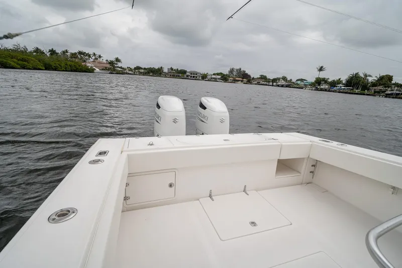 Slide: The Image of 2006 Venture Center Console boat with dual Suzuki engines on a calm waterway. - 47