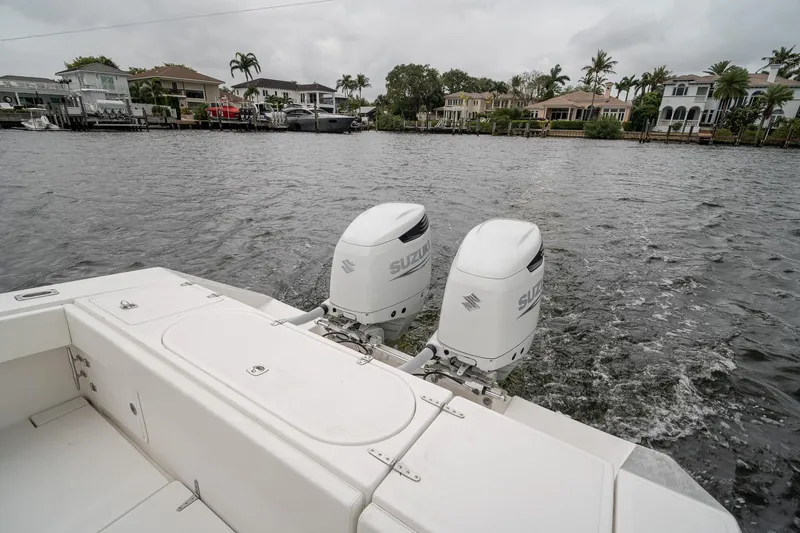 Slide: The Image of 2006 Venture Center Console boat with dual Suzuki outboard motors on a scenic waterway. - 50