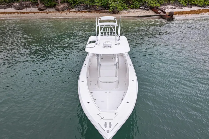 Slide: The Image of 2006 Venture Center Console boat near a sandy shoreline with lush greenery. - 7