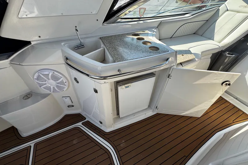 Slide: The Image of 2007 Monterey 330 Sport Yacht interior with sink, open cabinet, and wood flooring. - 17