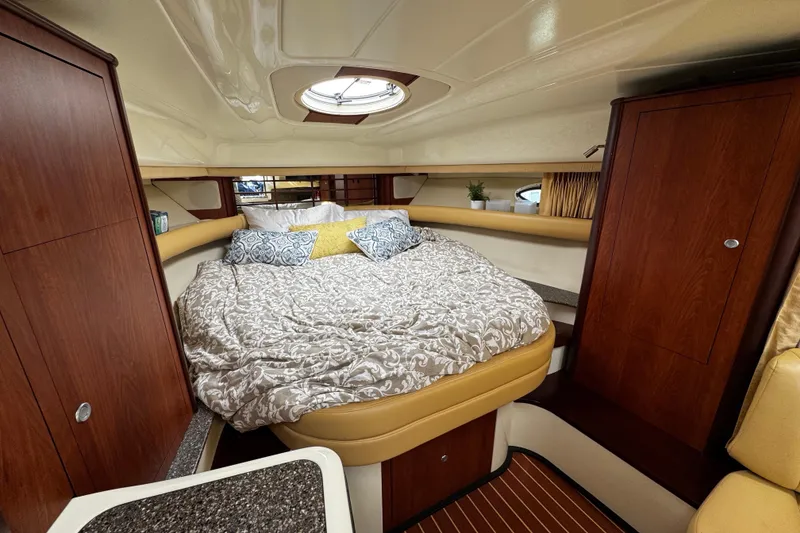 Slide: The Image of Luxurious cabin interior of a 2007 Monterey 330 Sport Yacht with cozy bedding and wood accents. - 25