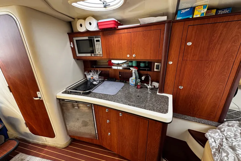 Slide: The Image of 2007 Monterey 330 Sport Yacht kitchen with microwave, sink, and wooden cabinetry. - 27