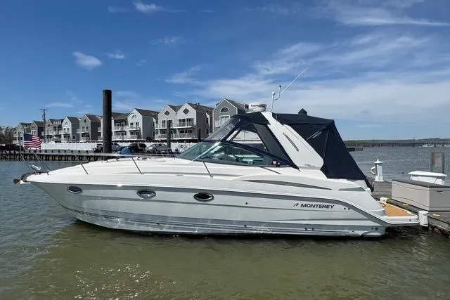 Slide: The Image of 2007 Monterey 330 Sport Yacht docked by waterfront homes under a clear blue sky. - 43