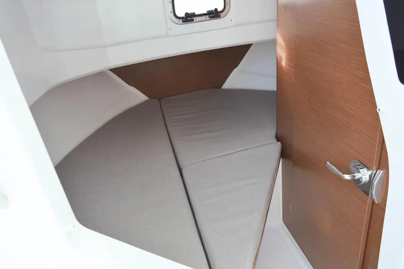 Slide: The Image of Manufacturer Provided Image: 2018 Jeanneau NC Sport 795 cabin interior with bed and wooden door. - 11