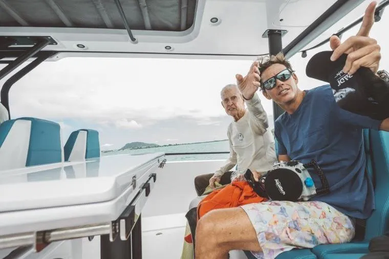 Slide: The Image of Two people relaxing on a 2027 Axopar 37 Sun-Top boat. - 2
