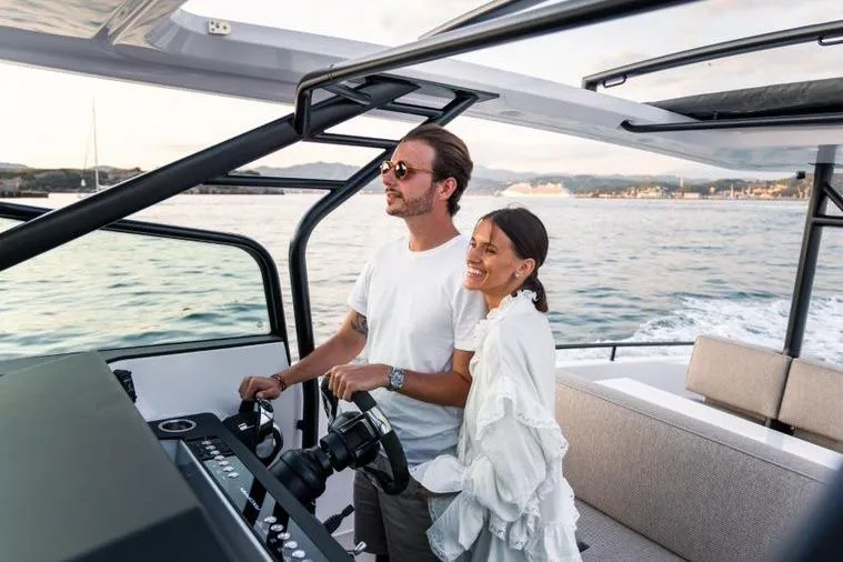 Slide: The Image of Couple enjoying a ride on a 2027 Axopar 37 Sun-Top boat, cruising on open water. - 5