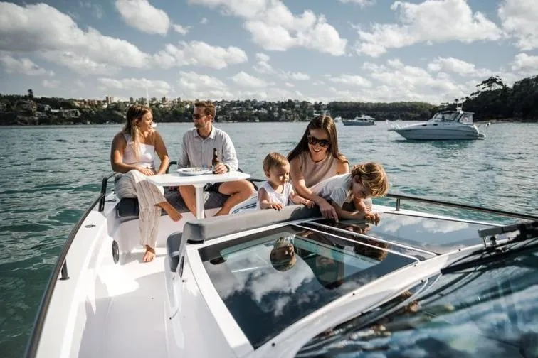 Slide: The Image of Family enjoying a day on a 2027 Axopar 37 Sun-Top boat, surrounded by scenic waters. - 9