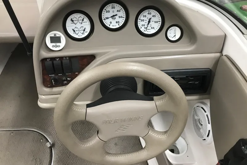 Slide: The Image of 2002 Four Winns 180 Horizon dashboard with steering wheel and gauges. - 13
