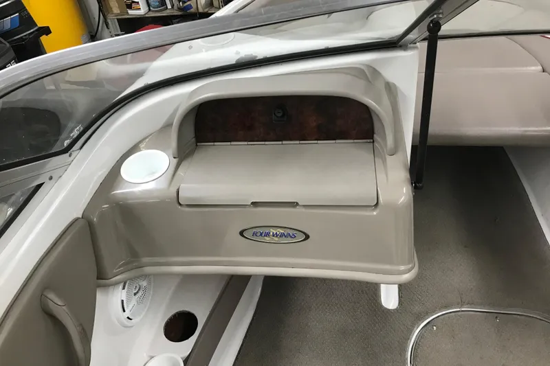 Slide: The Image of 2002 Four Winns 180 Horizon boat interior with glove compartment and cup holder. - 15