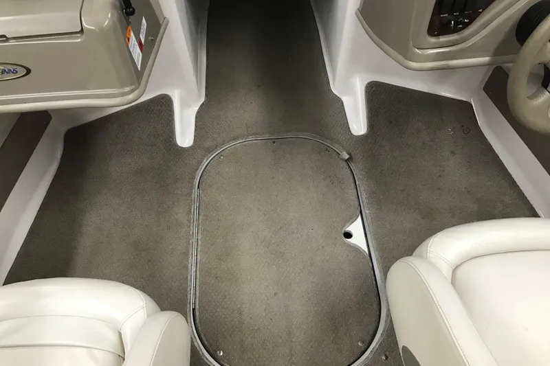 Slide: The Image of Interior of a 2002 Four Winns 180 Horizon boat, featuring beige carpet and seating. - 20
