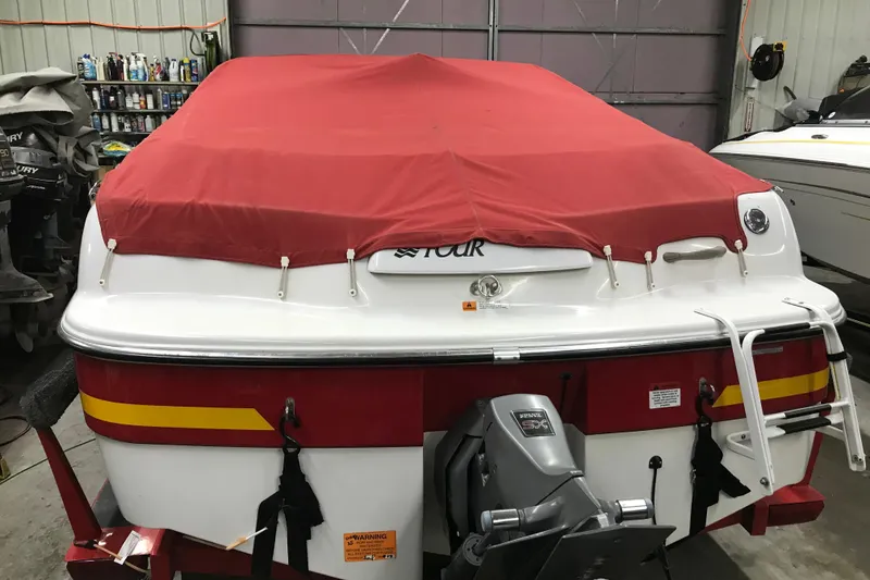 Slide: The Image of 2002 Four Winns 180 Horizon boat with red cover in a garage. - 24