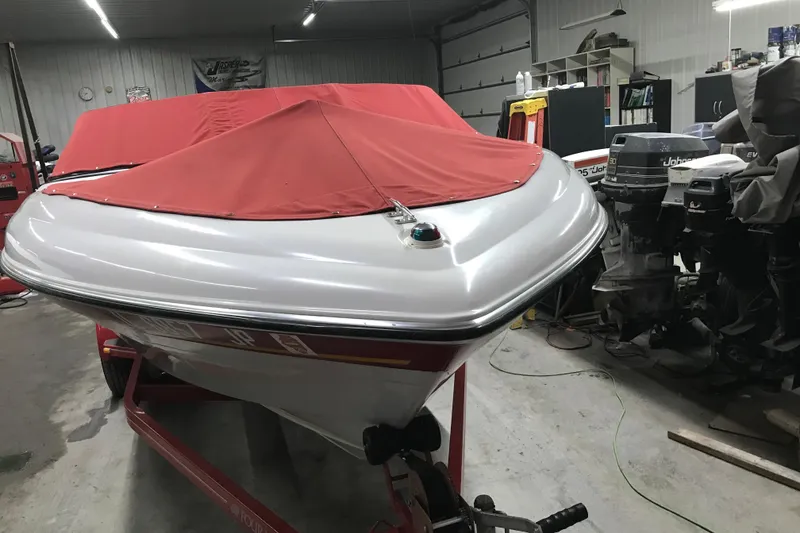 Slide: The Image of 2002 Four Winns 180 Horizon boat with red cover in a garage setting. - 25