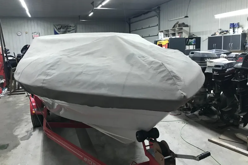 Slide: The Image of Covered 2002 Four Winns 180 Horizon boat in a garage with outboard motors. - 29
