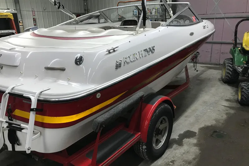 Slide: The Image of 2002 Four Winns 180 Horizon boat on trailer in garage setting. - 3