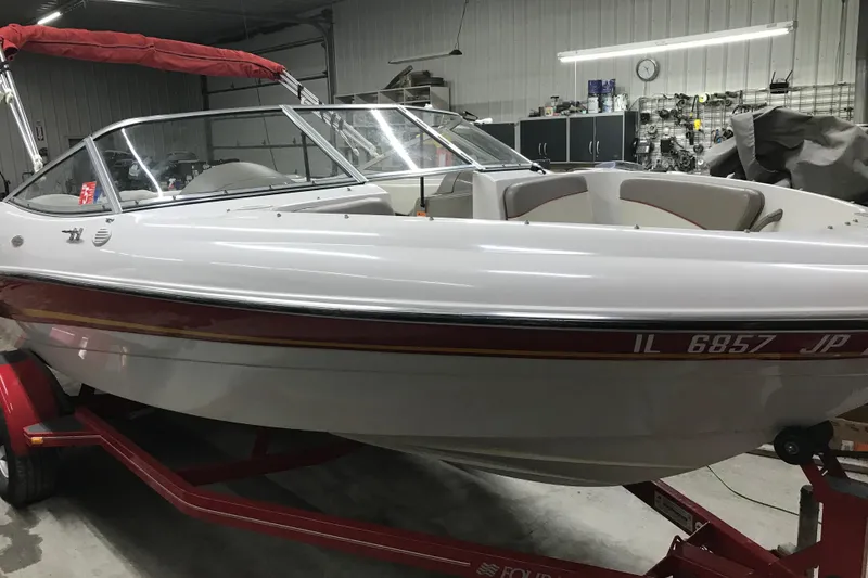 Slide: The Image of 2002 Four Winns 180 Horizon boat in a garage, red trailer, white hull, red canopy. - 8