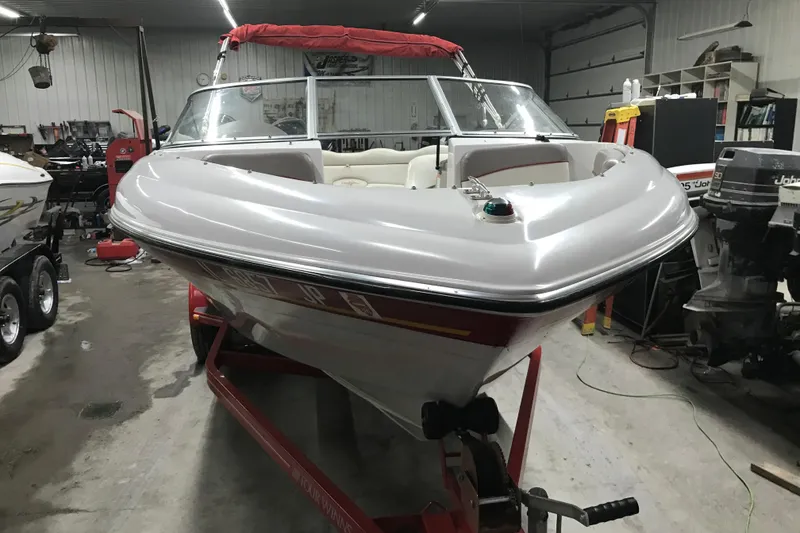 Slide: The Image of 2002 Four Winns 180 Horizon boat in a garage, on a red trailer. - 9