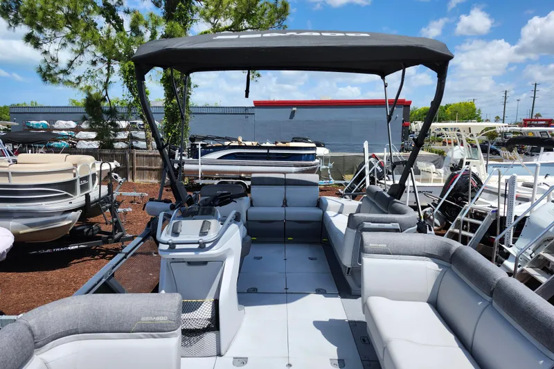 Slide: The Image of 2023 Sea-Doo Switch Cruise 21 pontoon boat with canopy, docked outdoors. - 11