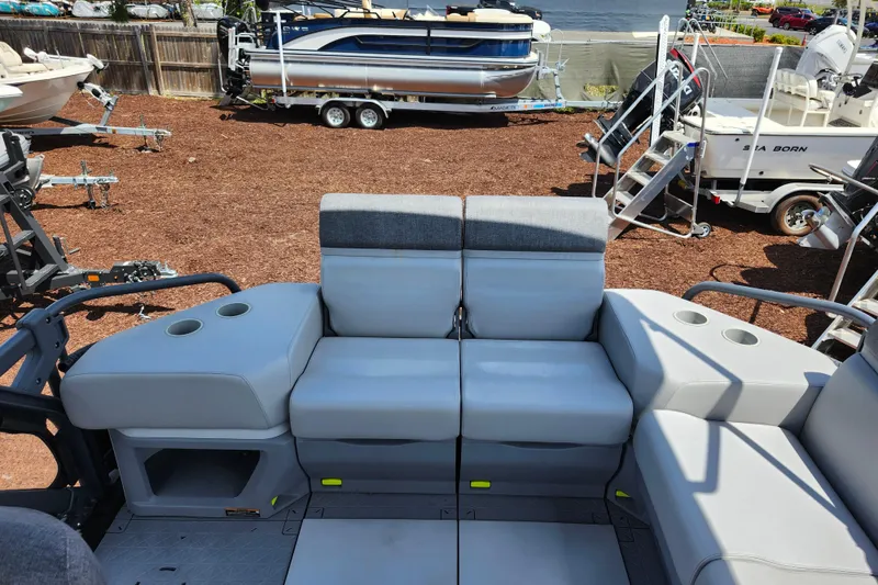 Slide: The Image of 2023 Sea-Doo Switch Cruise 21 interior seating with cup holders, parked on a trailer. - 19