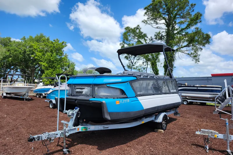 Slide: The Image of 2023 Sea-Doo Switch Cruise 21 pontoon boat on trailer, parked outdoors. - 3