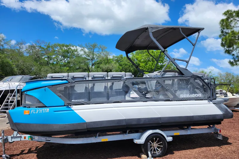 Slide: The Image of 2023 Sea-Doo Switch Cruise 21 pontoon boat on trailer under blue sky. - 4