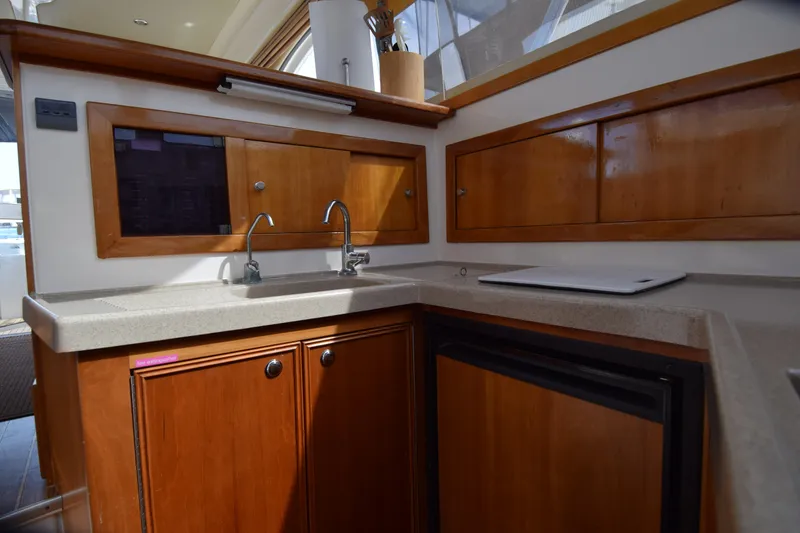 Slide: The Image of 2005 Riviera 33 Open Flybridge yacht kitchen with wooden cabinets and modern sink. - 11