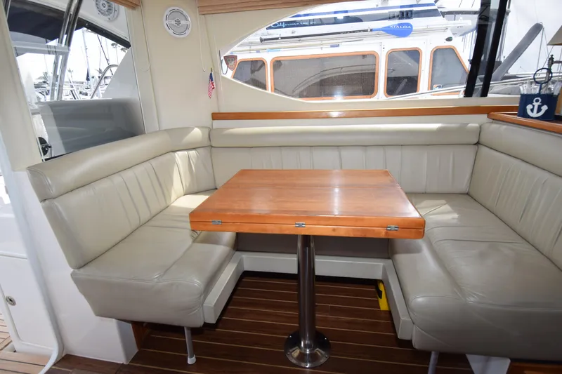 Slide: The Image of Luxurious seating area on 2005 Riviera 33 Open Flybridge yacht with wooden table. - 12