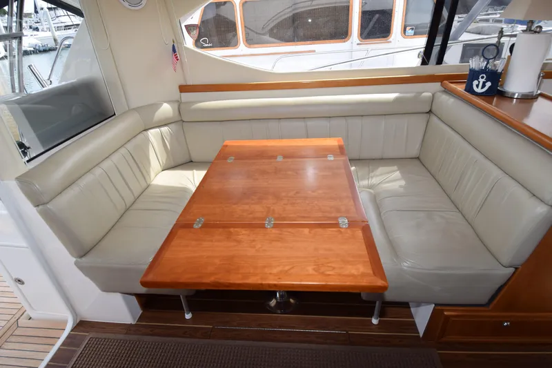 Slide: The Image of Luxurious interior of 2005 Riviera 33 Open Flybridge with plush seating and wooden table. - 14