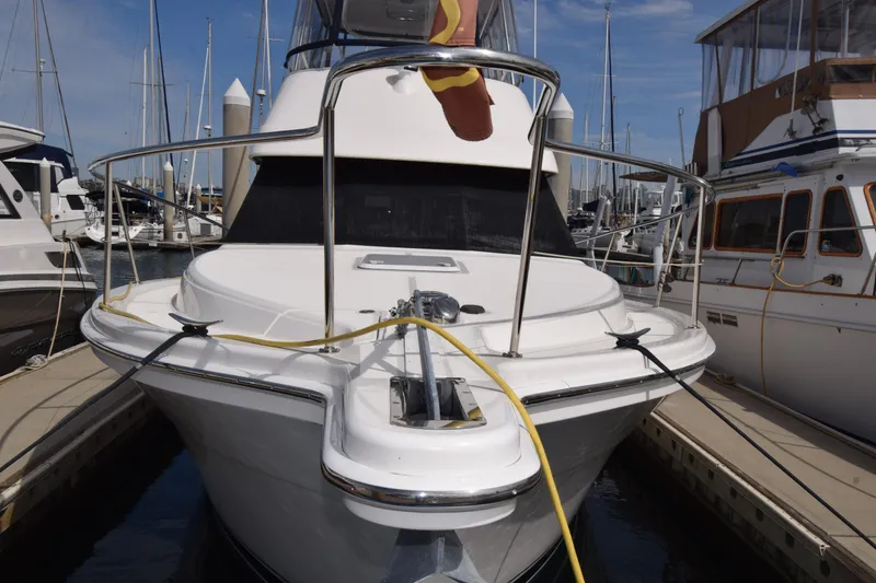 Slide: The Image of 2005 Riviera 33 Open Flybridge yacht docked at marina, surrounded by other boats. - 40
