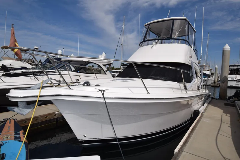 Slide: The Image of 2005 Riviera 33 Open Flybridge yacht docked at marina under blue sky. - 41