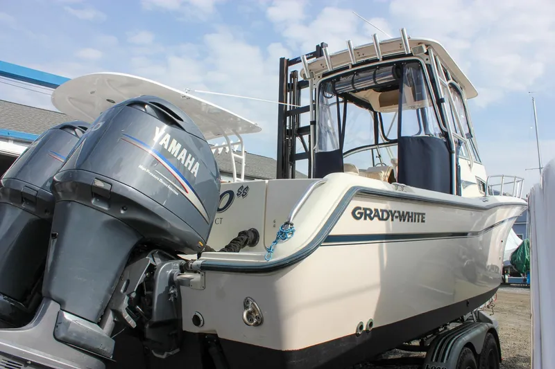 The Image of 2002 Grady-White Islander 270 boat with Yamaha engines, docked under a clear sky. - 0