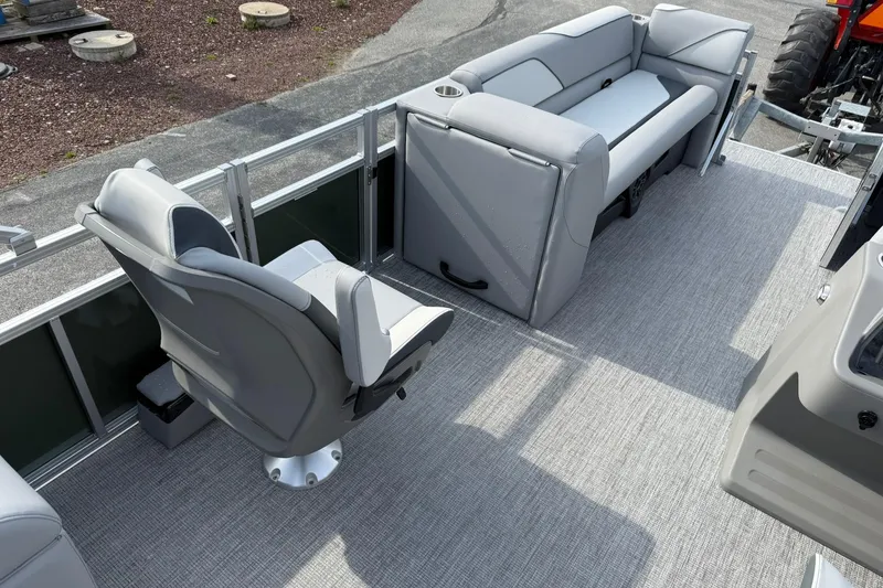 Slide: The Image of 2026 Avalon Venture Quad Lounge 23' boat interior with gray seating and carpeted floor. - 15
