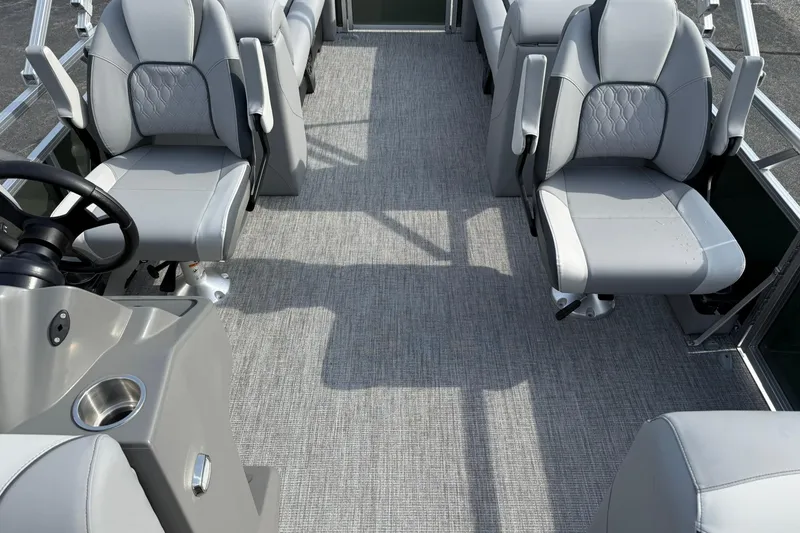 Slide: The Image of 2026 Avalon Venture Quad Lounge boat interior with gray seating and steering console. - 9