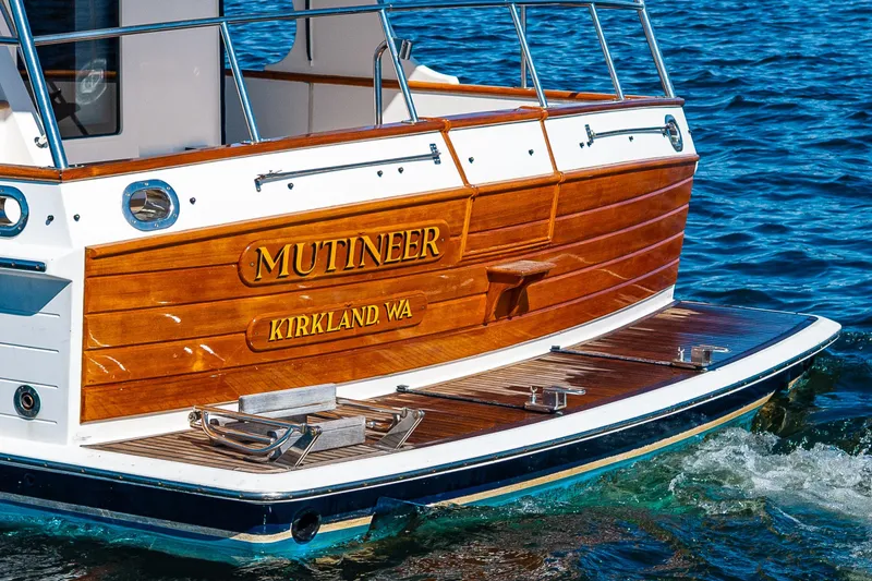 Slide: The Image of Grand Banks 47 Europa 2006 yacht with wooden stern, named "Mutineer," on blue water. - 10