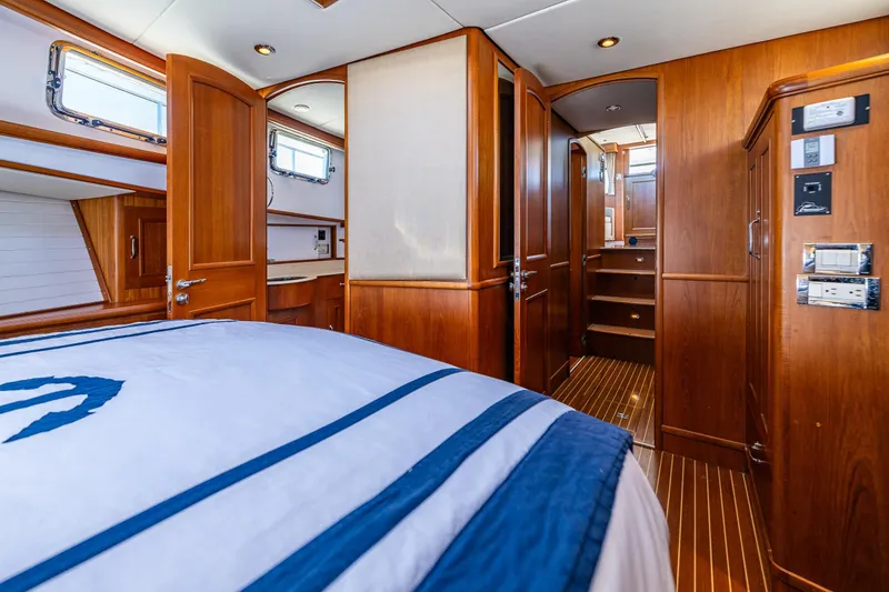 Slide: The Image of Luxurious 2006 Grand Banks 47 Europa yacht interior with wood paneling and cozy bedroom. - 11